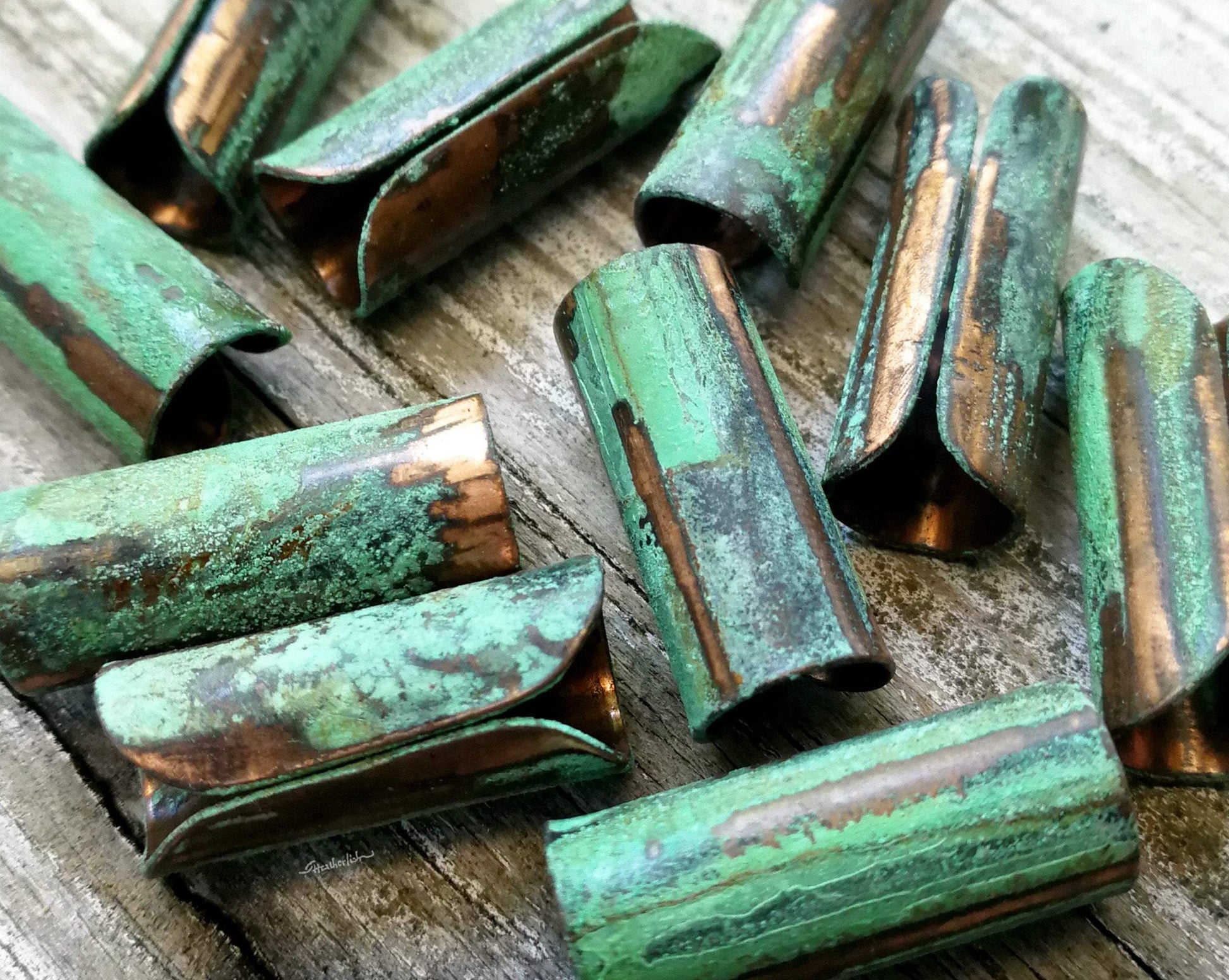 A close up view of Green Patina Copper Tube Beads.
