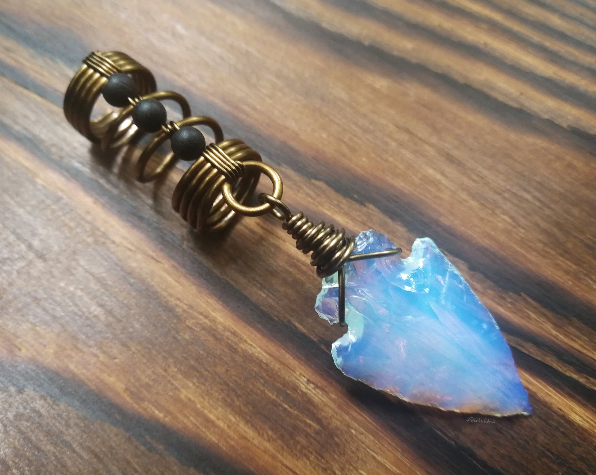 A back view of a Opalite Glass Arrowhead Dread Bead.