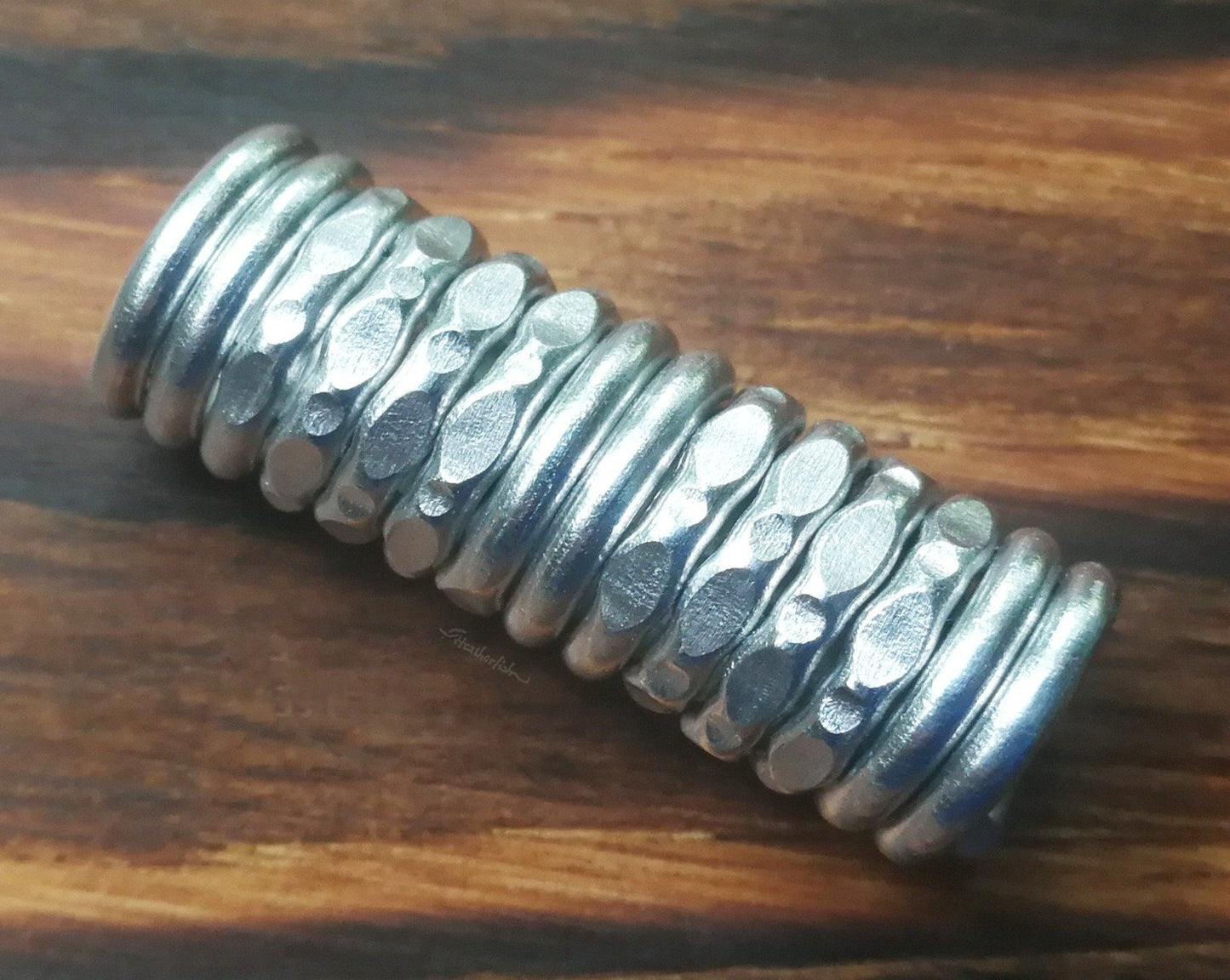 A textured dread bead displayed on wood