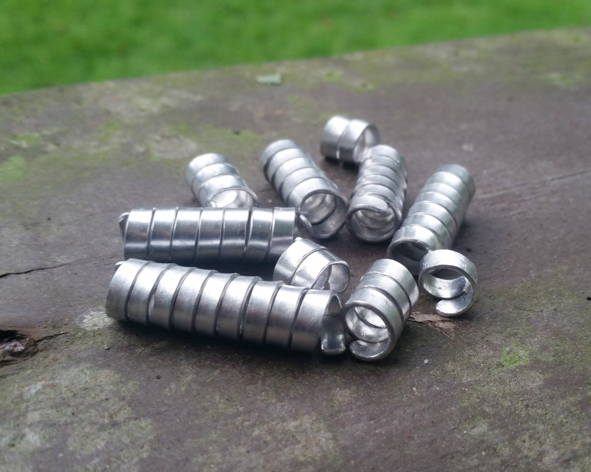 Set of 10 varied length aluminum dread beads in pile