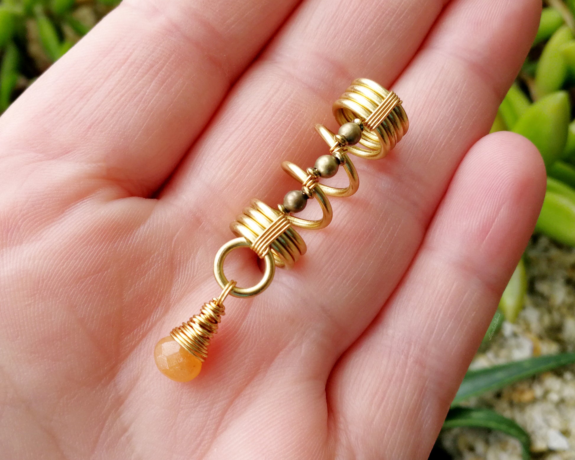 Gold aventurine hair jewelry held in a hand to show scale.