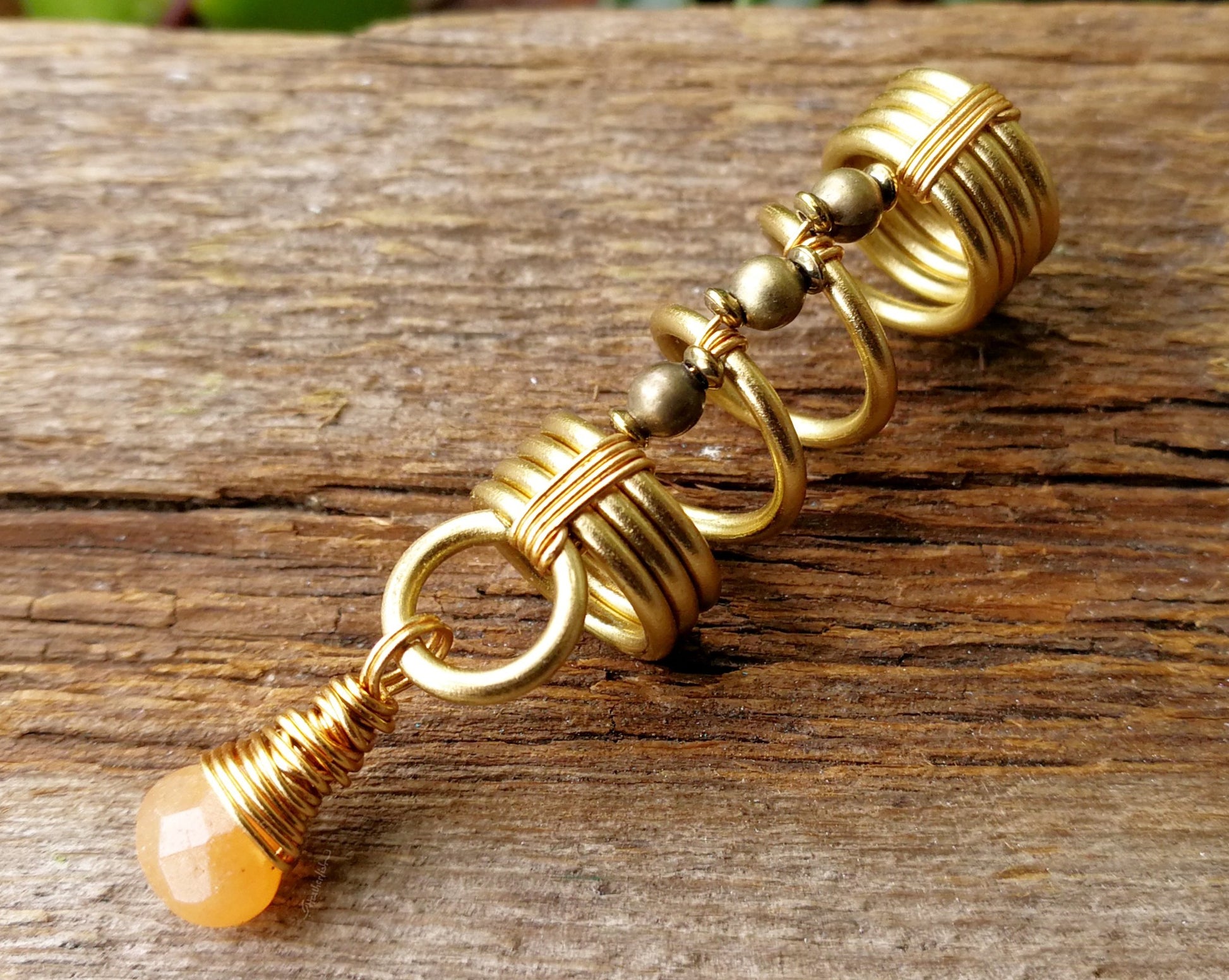 Gold aventurine hair jewelry on a wood background.