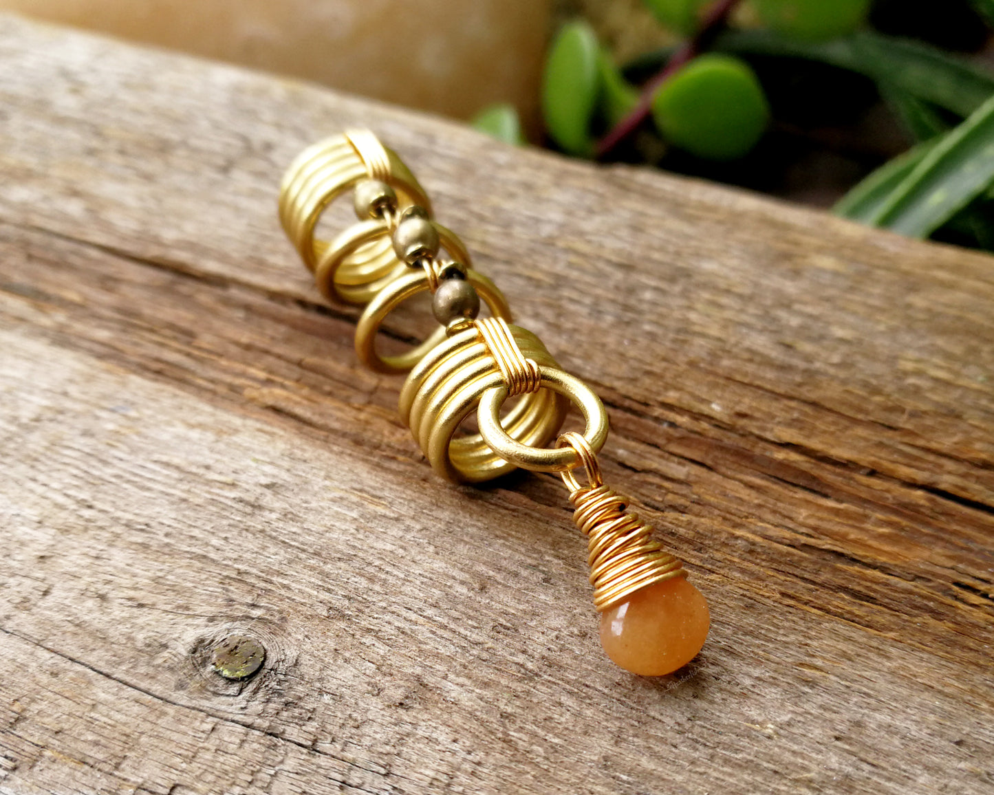 Gold aventurine hair jewelry on a wood background.