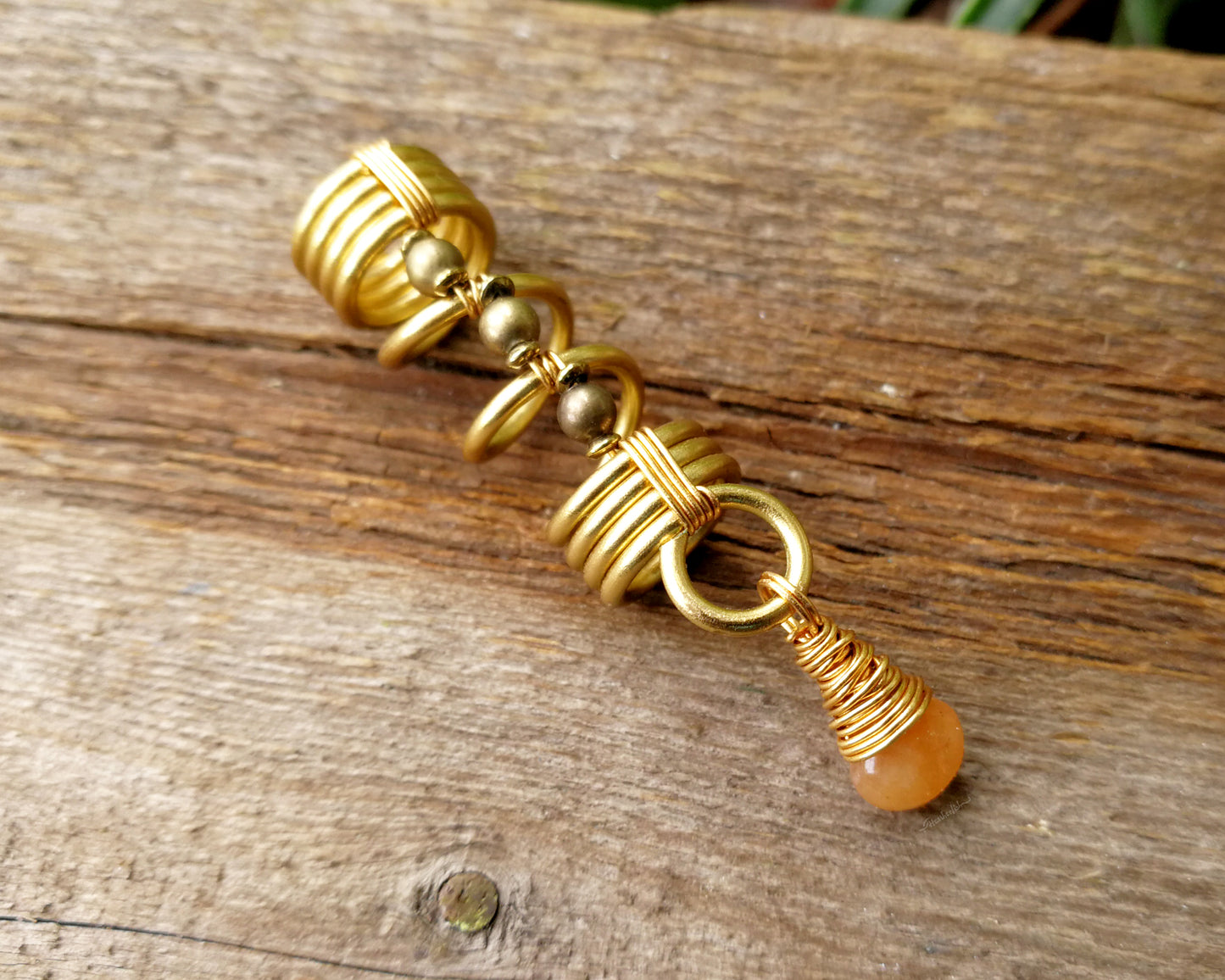 Gold aventurine hair jewelry on a wood background.