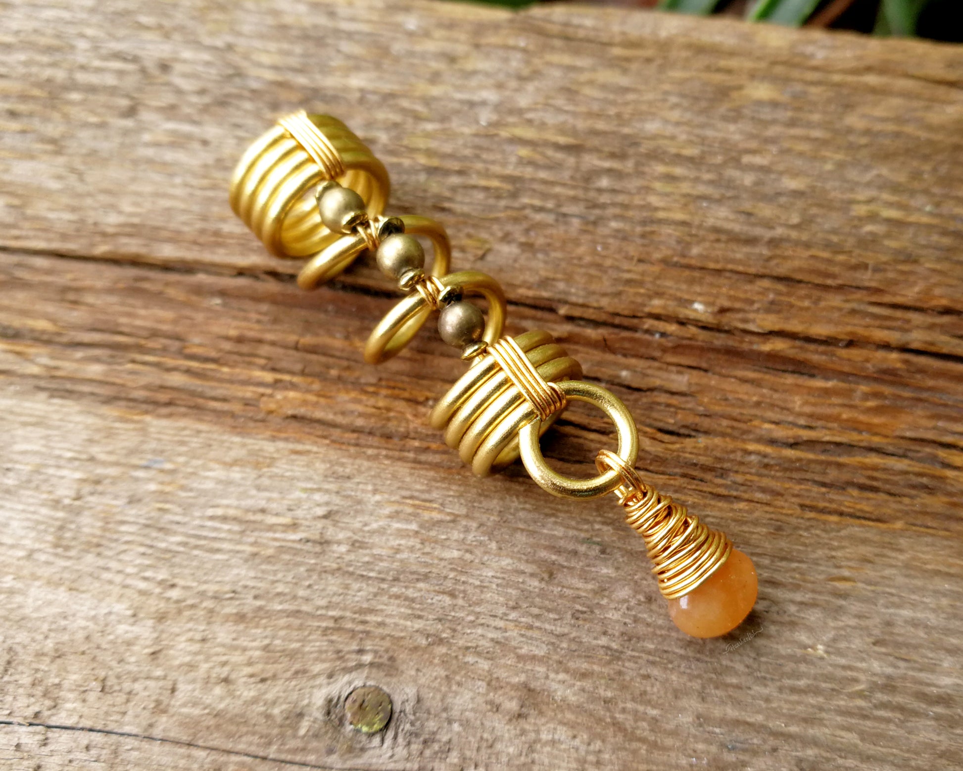 Gold aventurine hair jewelry on a wood background.