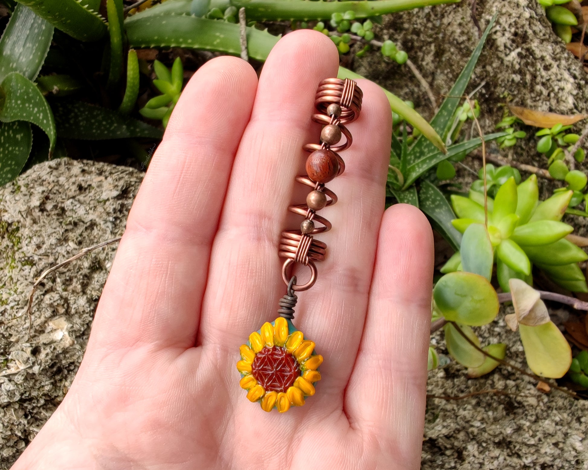 Glass Sunflower Dread Bead in hand to show scale.