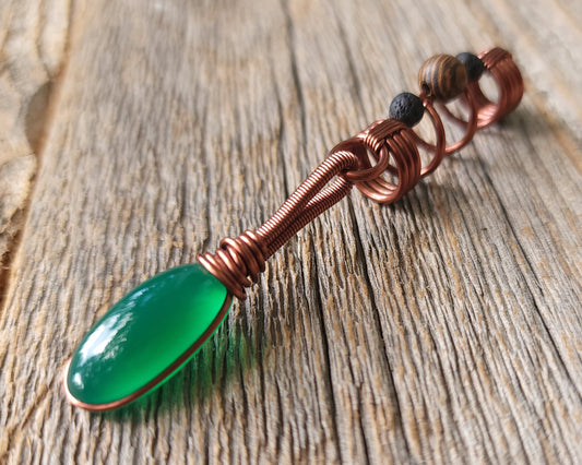 Green onyx earth dread bead on wood background.