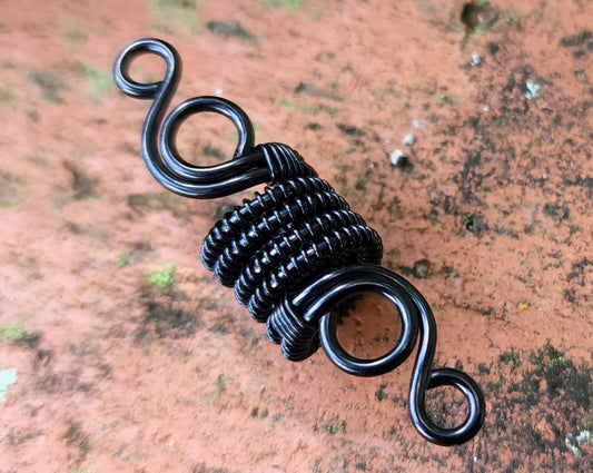 Woven Filigree Dread Bead on brick backgound.