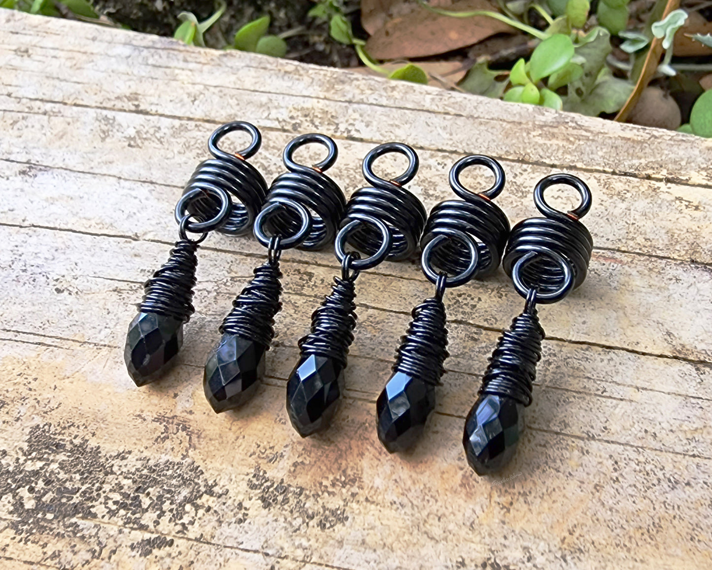 Black Glass Loc Beads, Set of 5 on wood background.