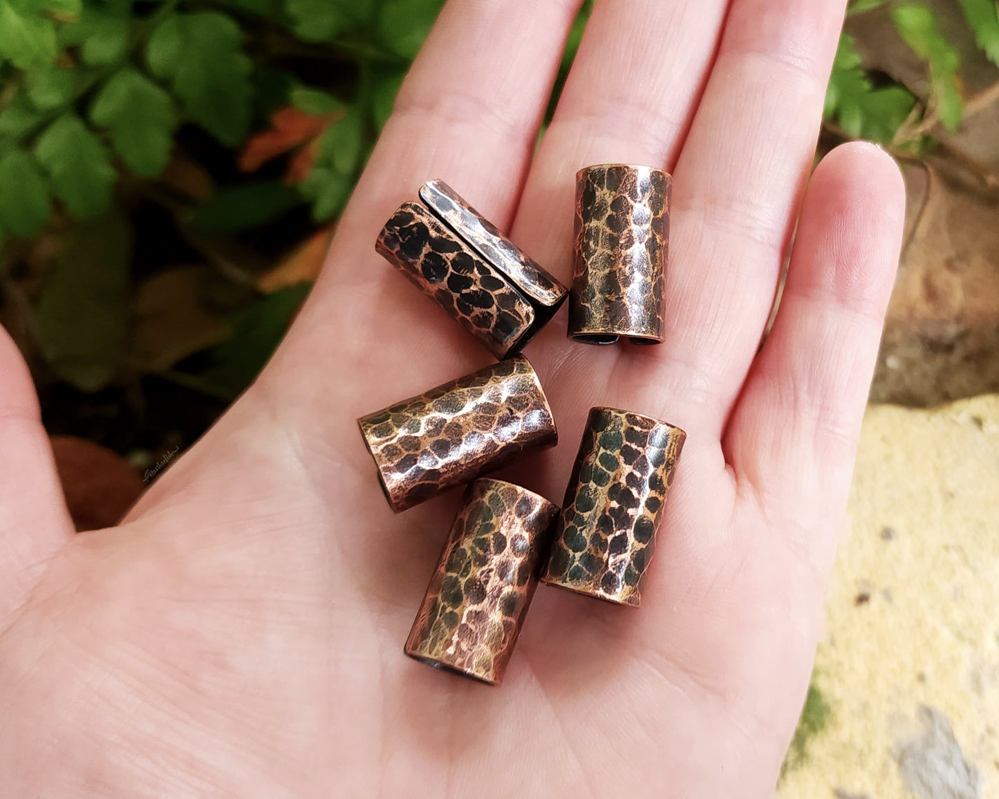 Textured Oxidized Copper Cuffs held in hand to show scale.