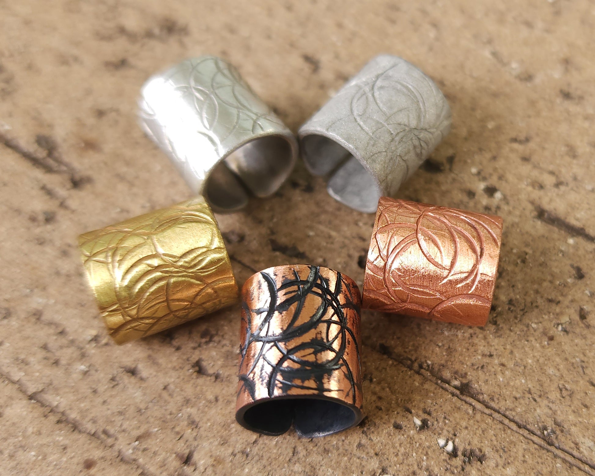 Textured hair cuff options on a brick background.