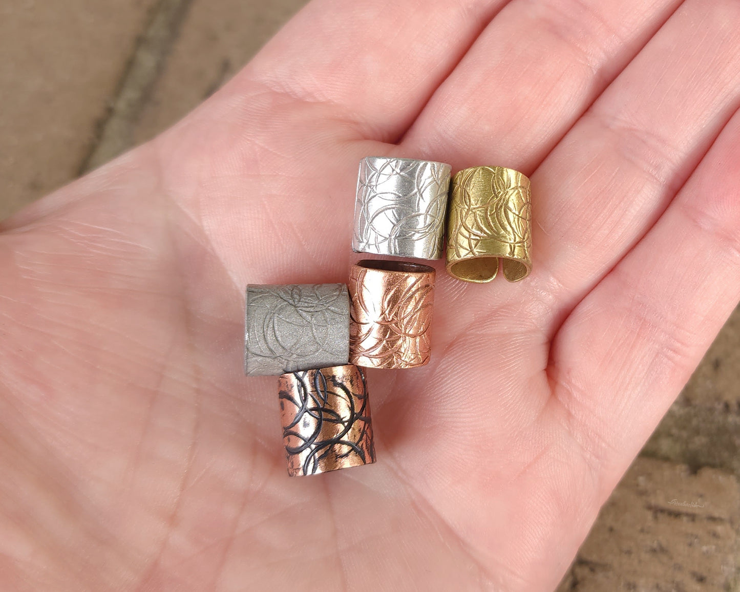 Textured hair cuff options held in hand to show scale.