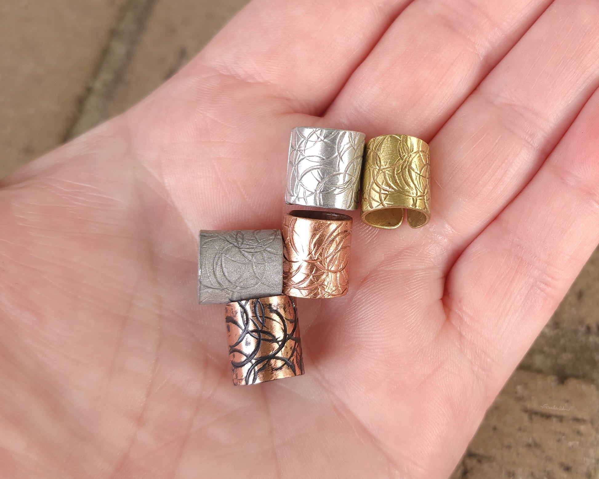 Textured hair cuff options held in hand to show scale.