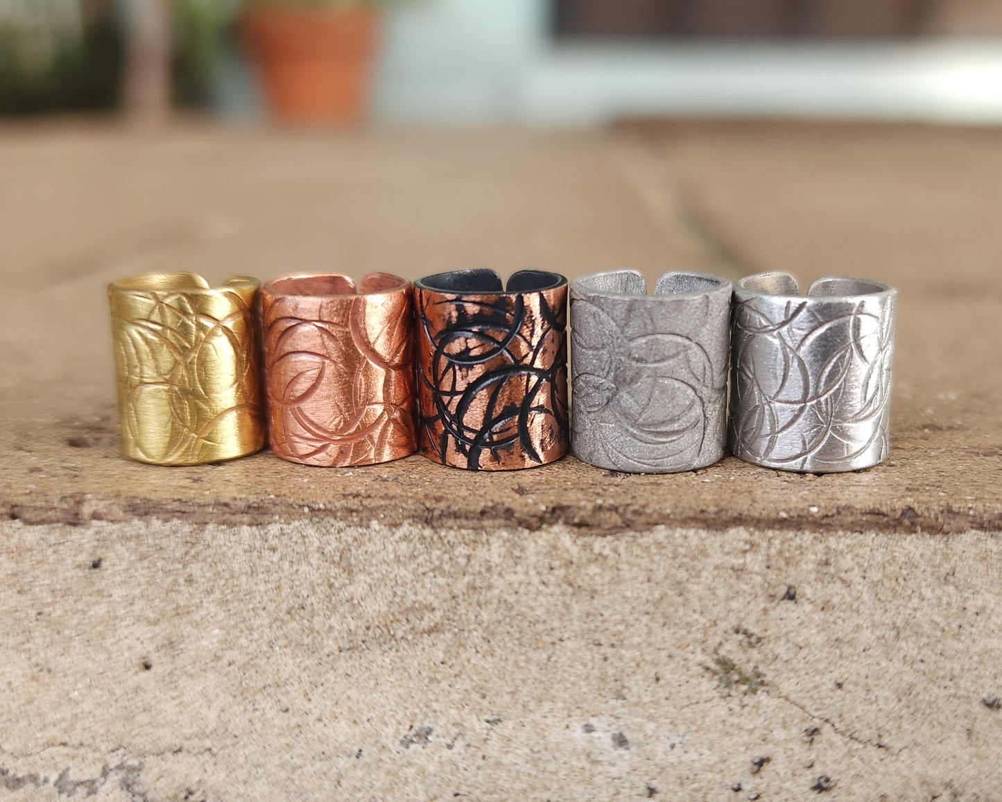 Textured hair cuff options on a brick background.