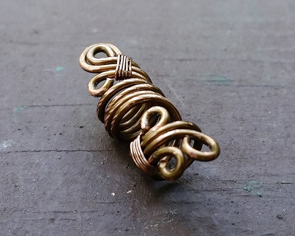 A side view of a Rustic Filigree Dread Bead.