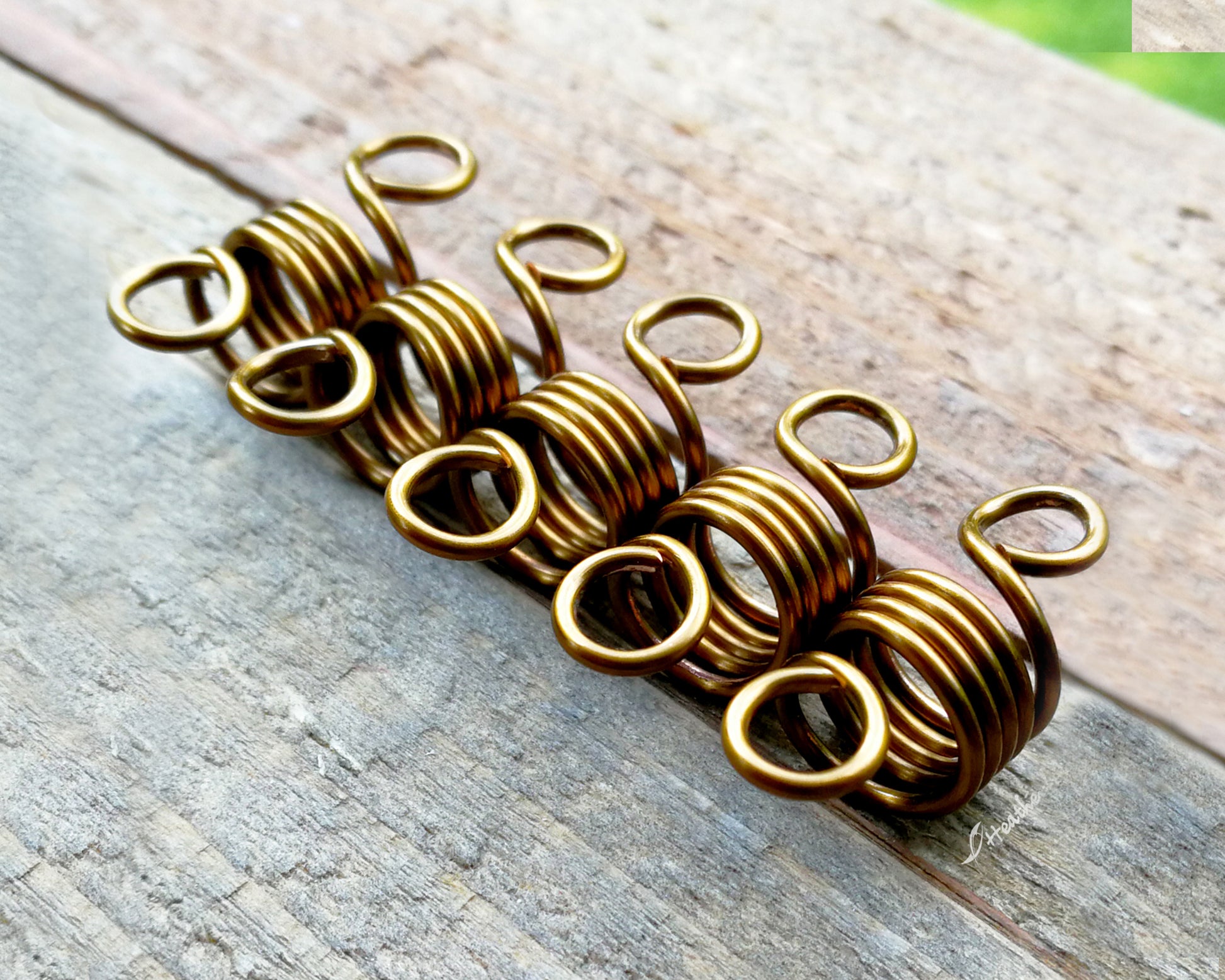 A set of 5 hair beads on a wood background.