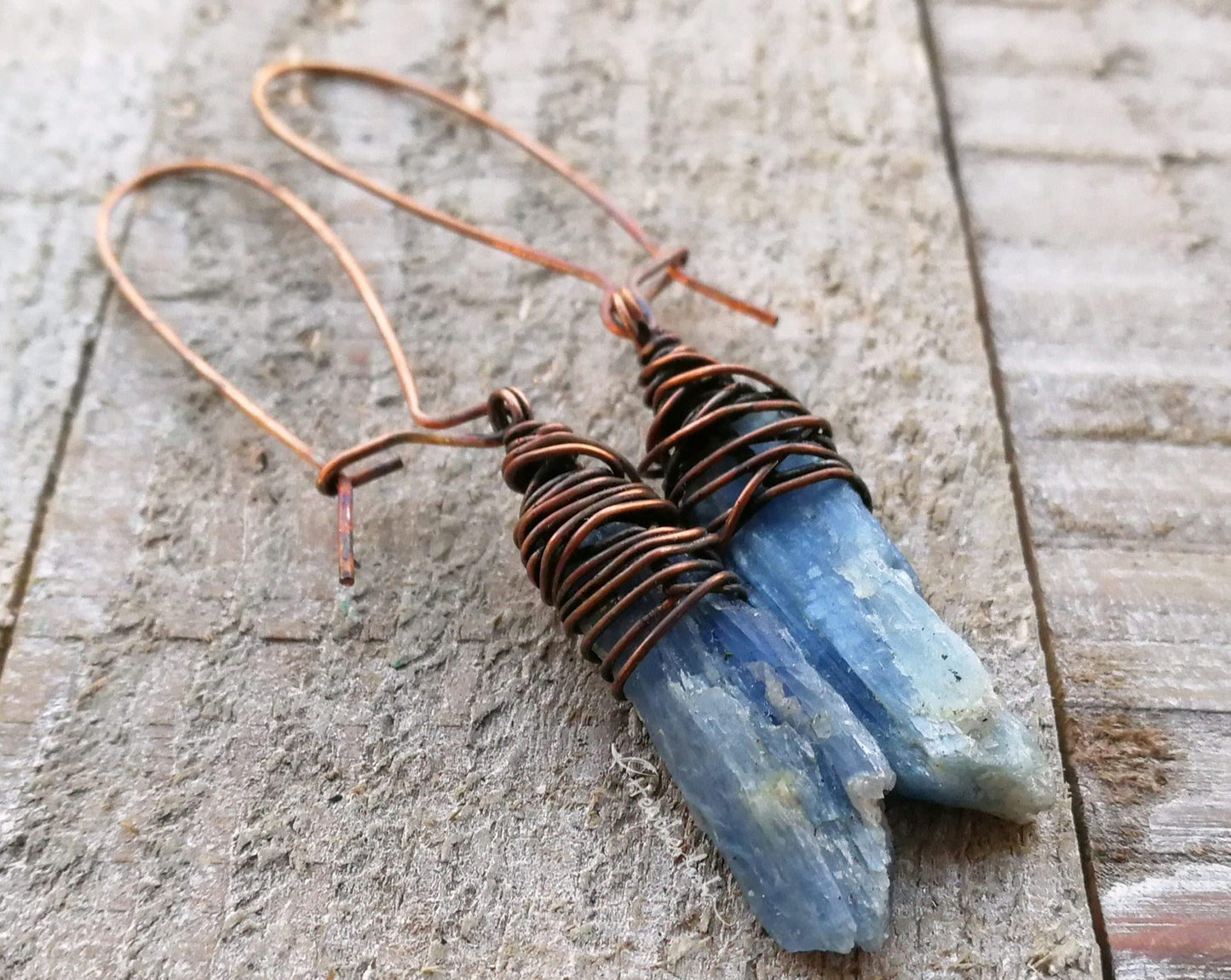 A pair of Blue Kyanite Earrings close up on a wooden background