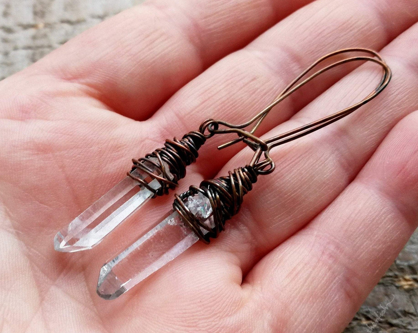 A pair of crystal earrings in hand.