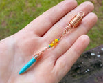 A top view of a Turquoise Spike Dread Bead in hand.