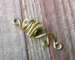 A close up view of a Small Woven Brass Dread Bead.