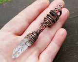 A top view of the Crystal Dread Bead wrapped in Oxidized Copper in hand.