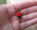 A top view of a Red Rose Dread Bead in hand.