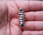 A top view of a Textured Aluminum Dreadlock Bead in hand.