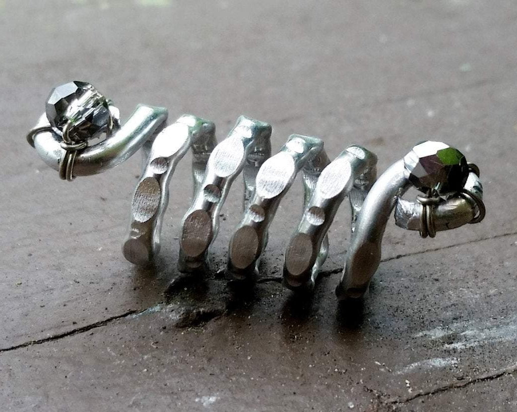 A side view of a Textured Aluminum Dreadlock Bead.