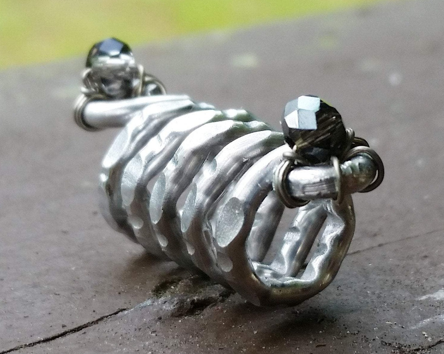 A side view of a Textured Aluminum Dreadlock Bead.