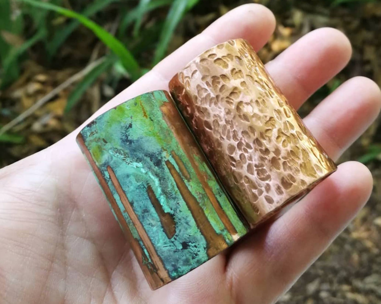 Two copper hair cuffs held in hand to show scale and finish.