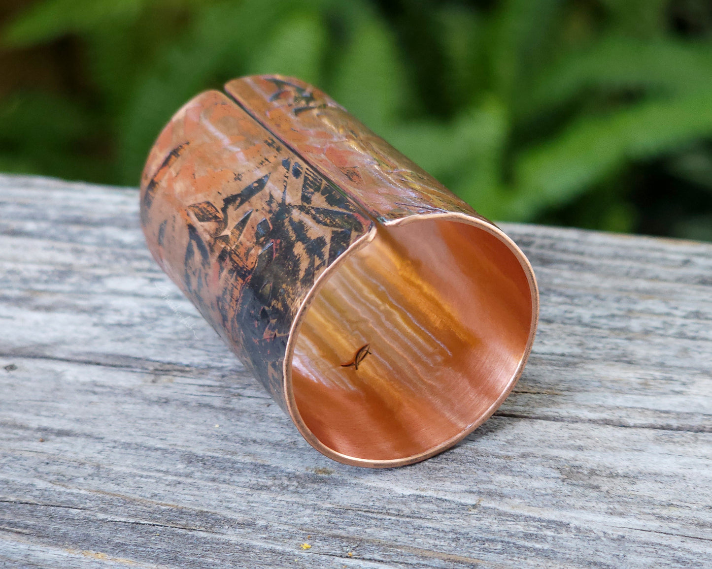 A large texturized hair cuff in copper displayed on a rustic wood board.