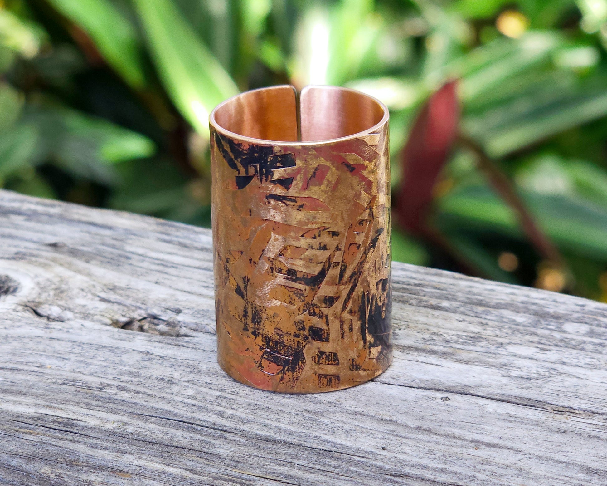 A large texturized hair cuff in copper displayed on a rustic wood board.