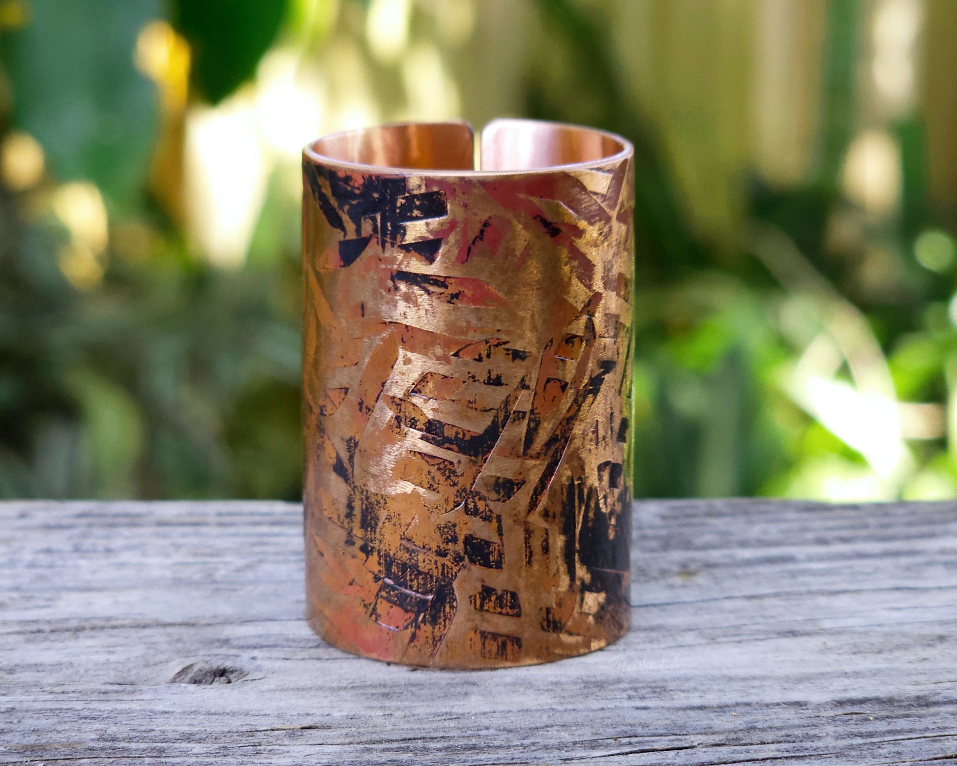 A large texturized hair cuff in copper displayed on a rustic wood board.
