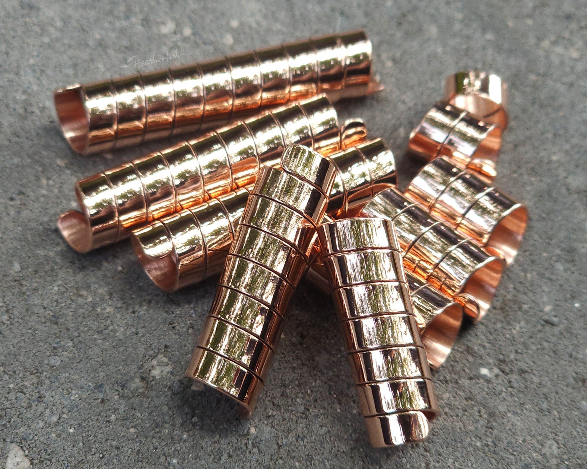Varied length copper hair coils on a stone background.