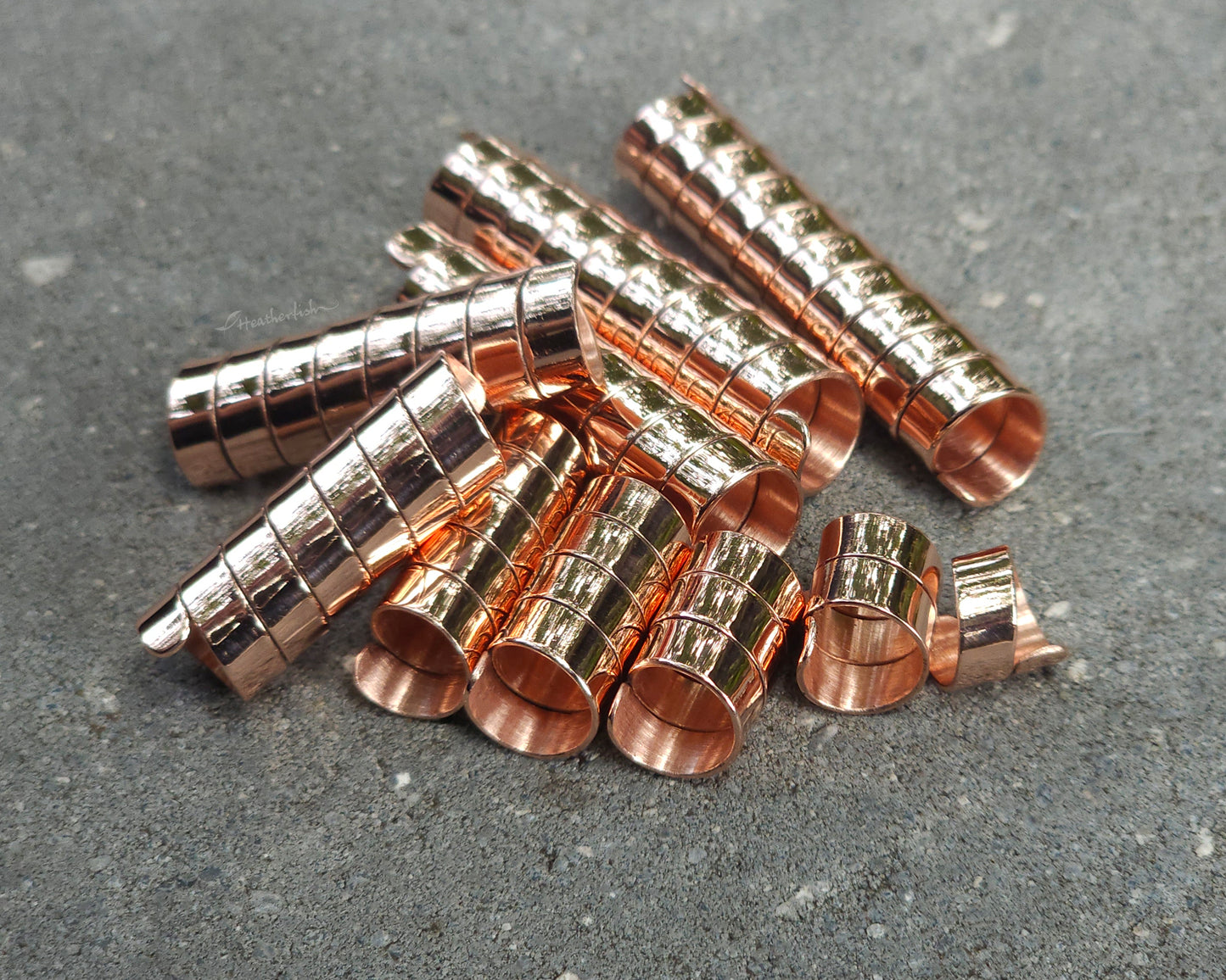 Varied length copper hair coils on a stone background.