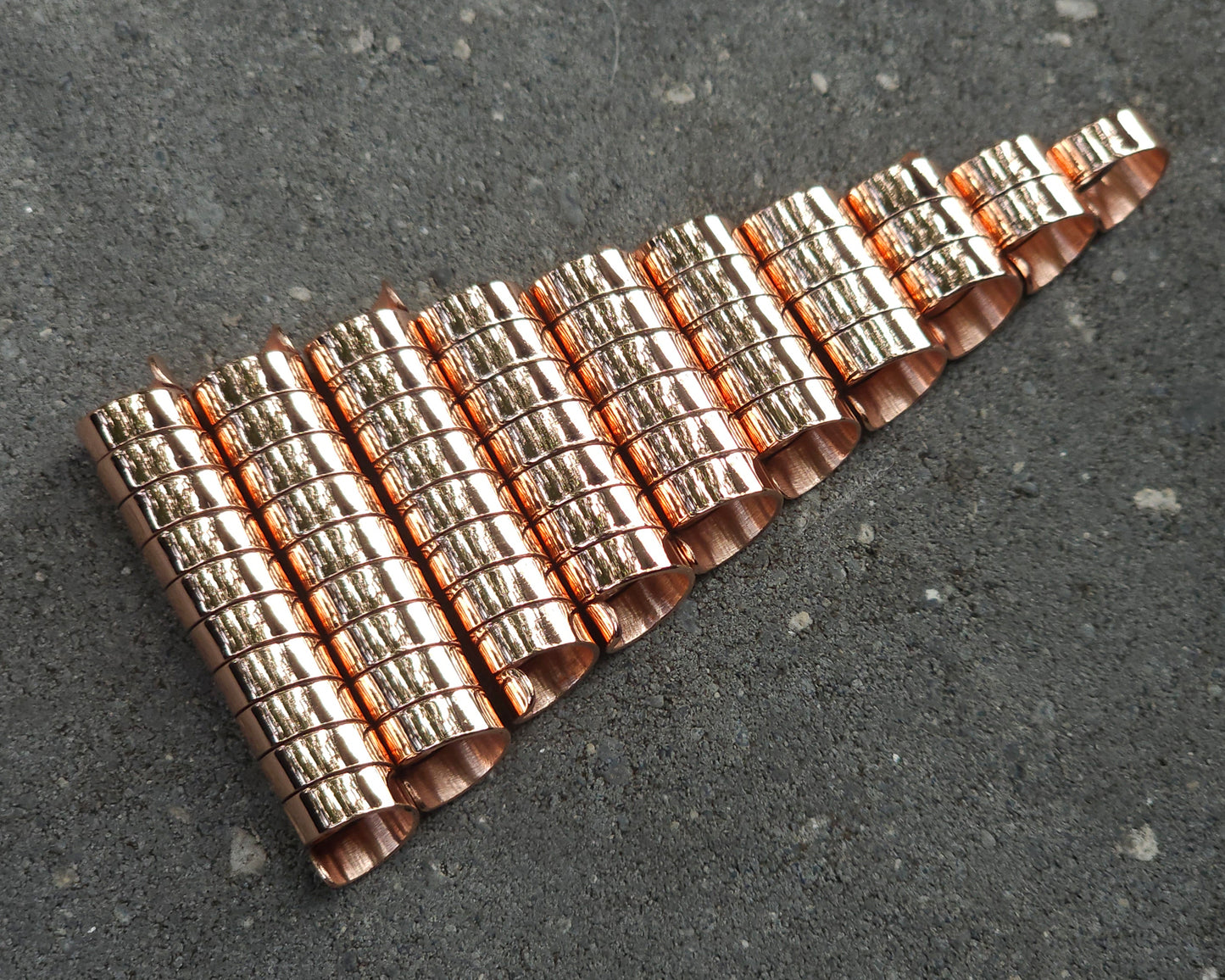 Varied length copper hair coils on a stone background.