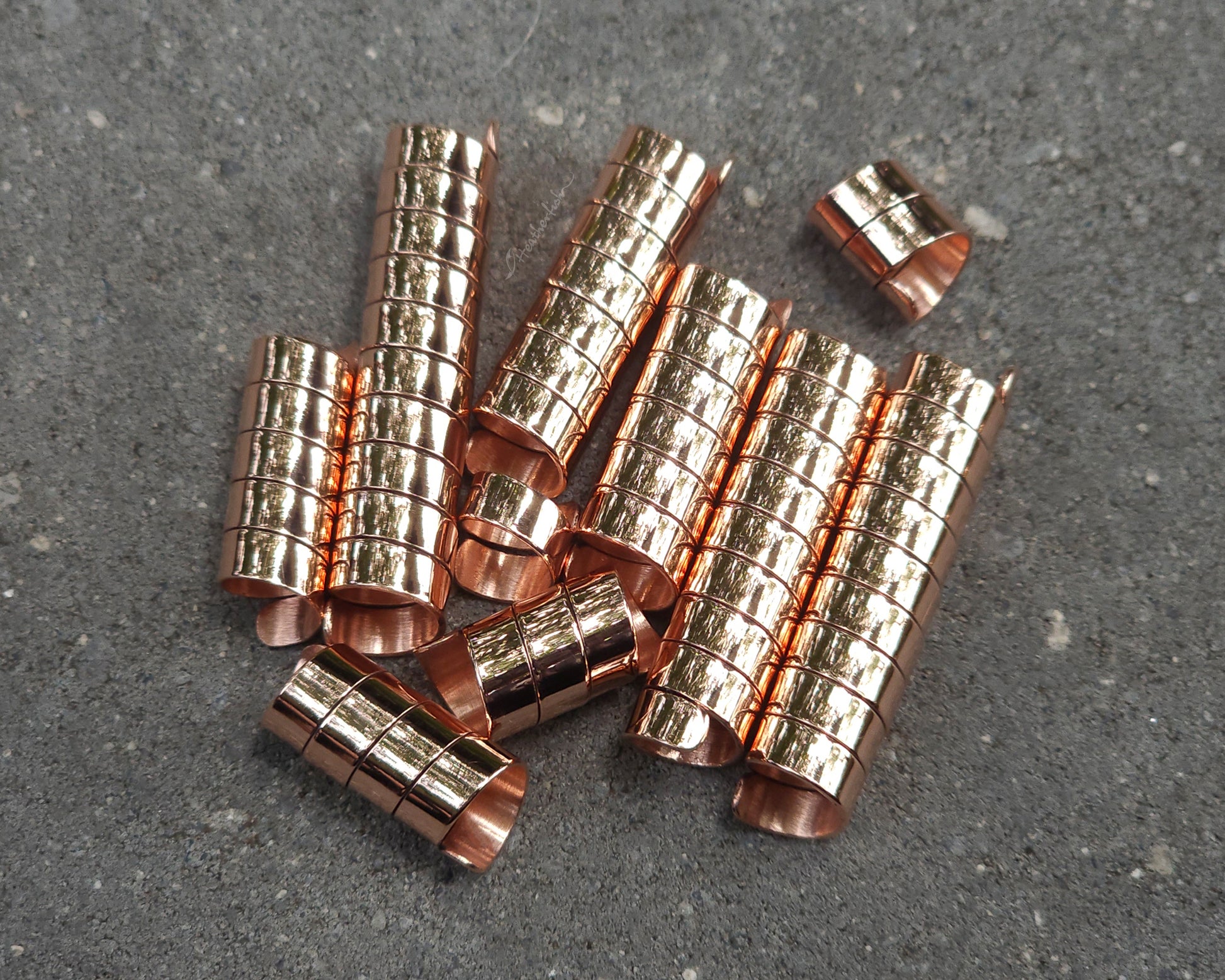 Varied length copper hair coils on a stone background.