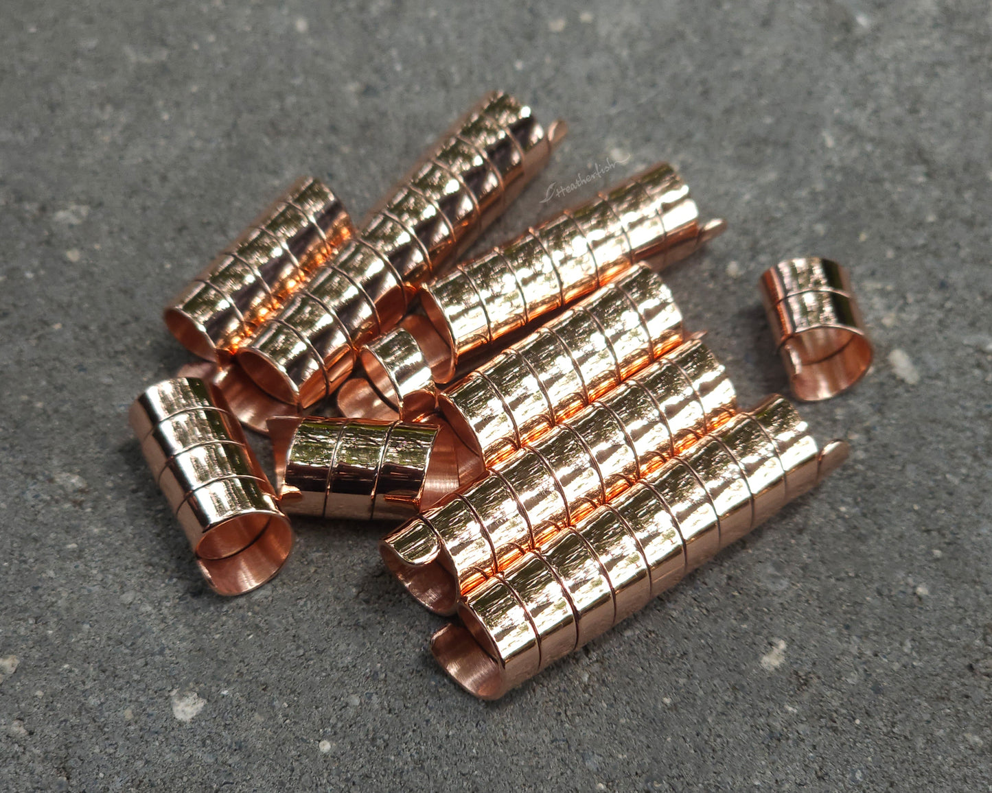 Varied length copper hair coils on a stone background.