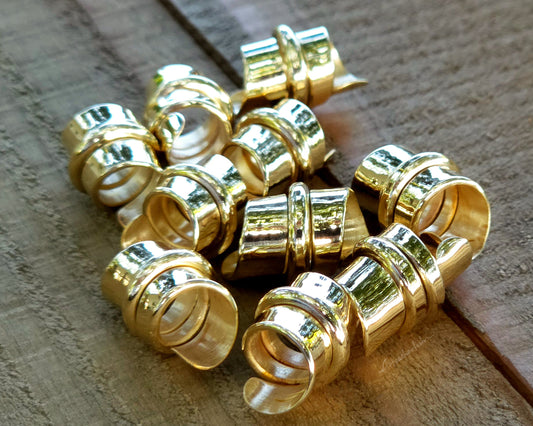 Red brass hair beads on a wood background.