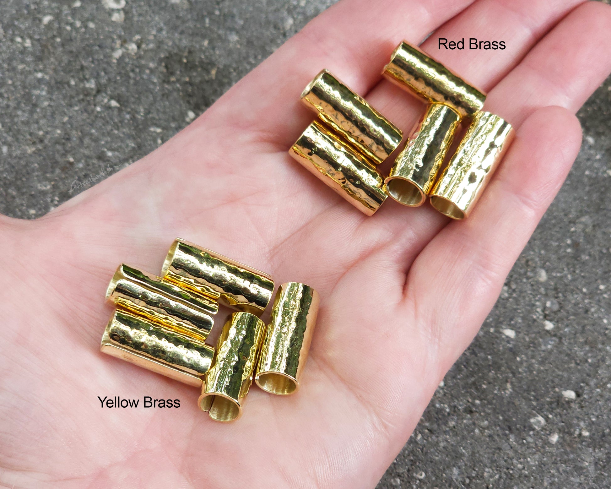 Brass hair cuffs held in hand to show scale.