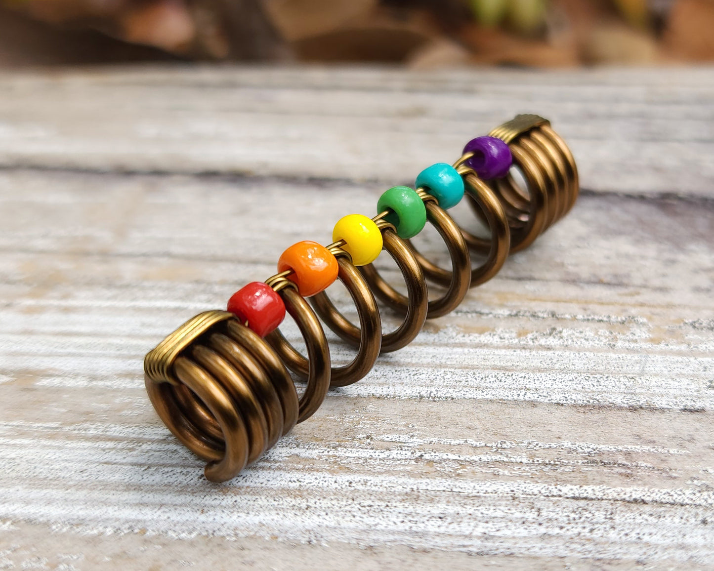 LGBTQIA+ pride loc bead on wood background.