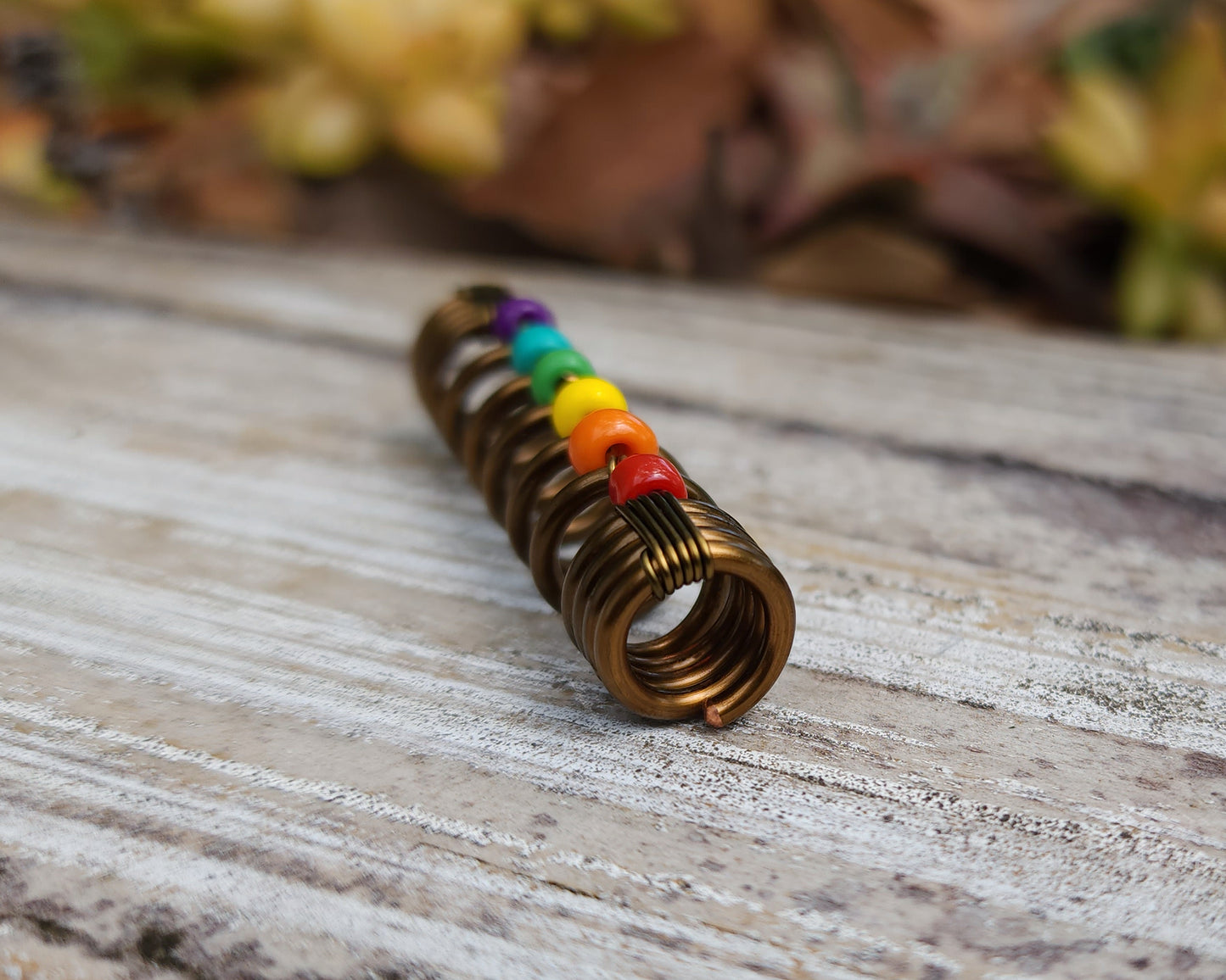 LGBTQIA+ pride loc bead on wood background.