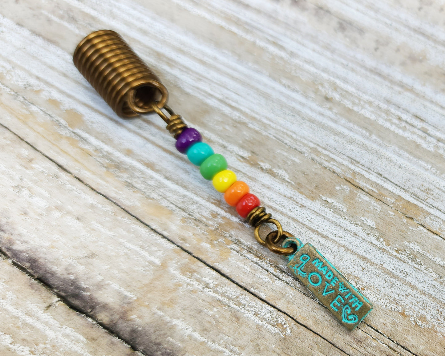 Made with Love Pride Loc Jewelry on a wood background.