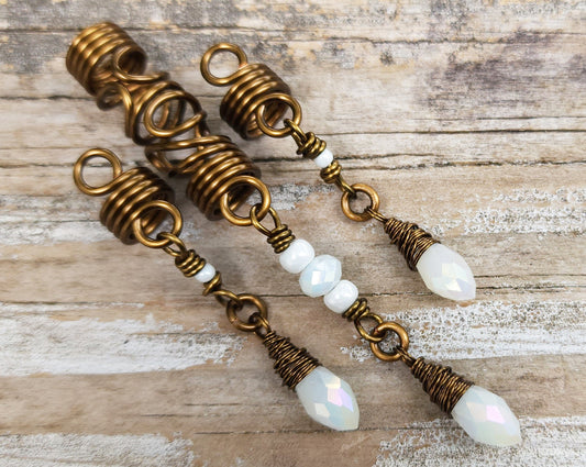 Set of 3 White Glass Loc Beads on wood background.