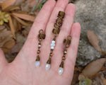 Set of 3 White Glass Loc Beads held in hand to show scale.
