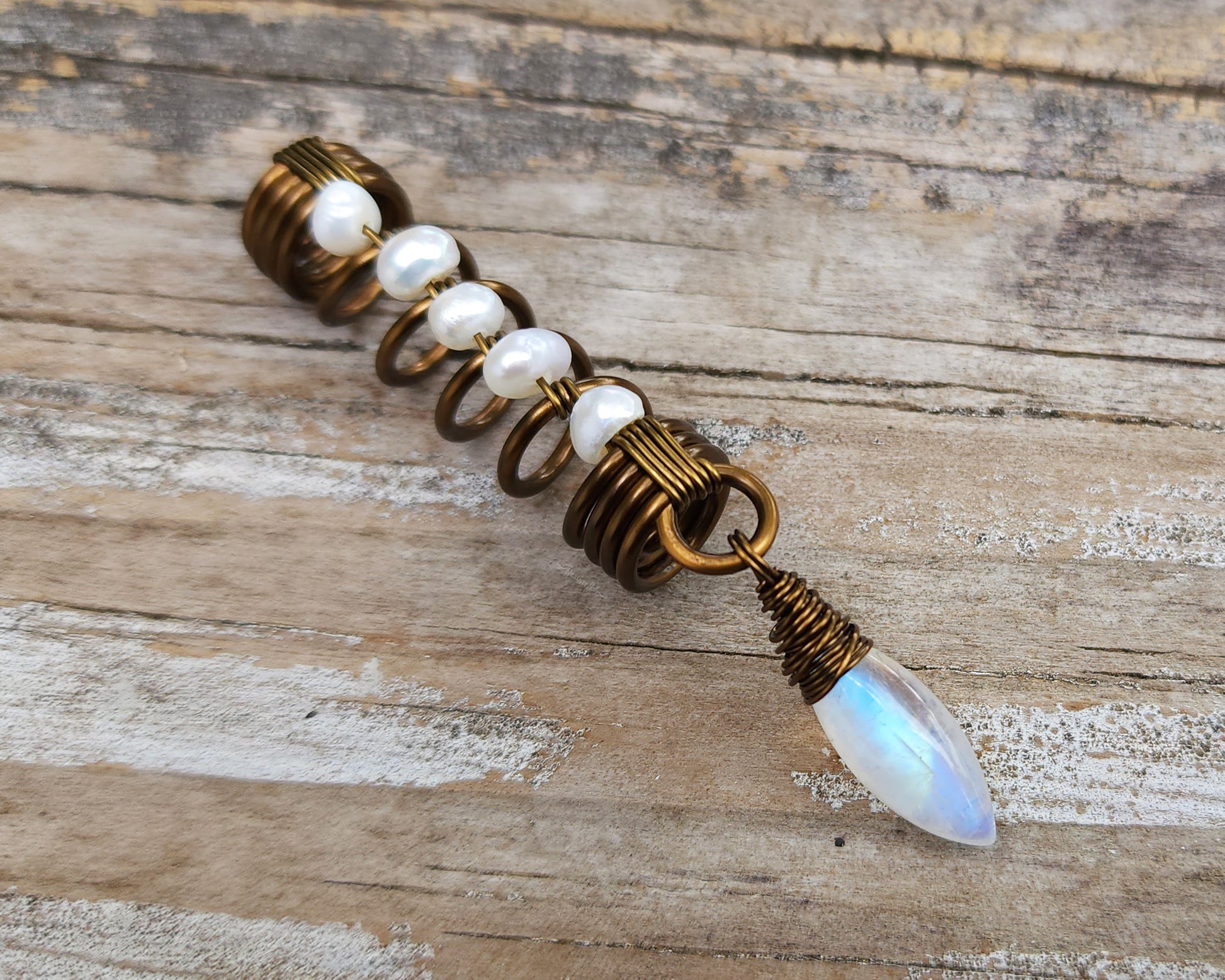 Pearl Moonstone Loc Bead on a wood background.