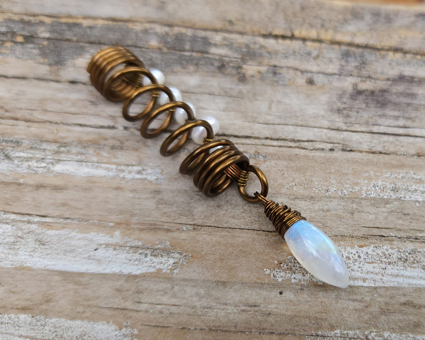 Pearl Moonstone Loc Bead on a wood background.