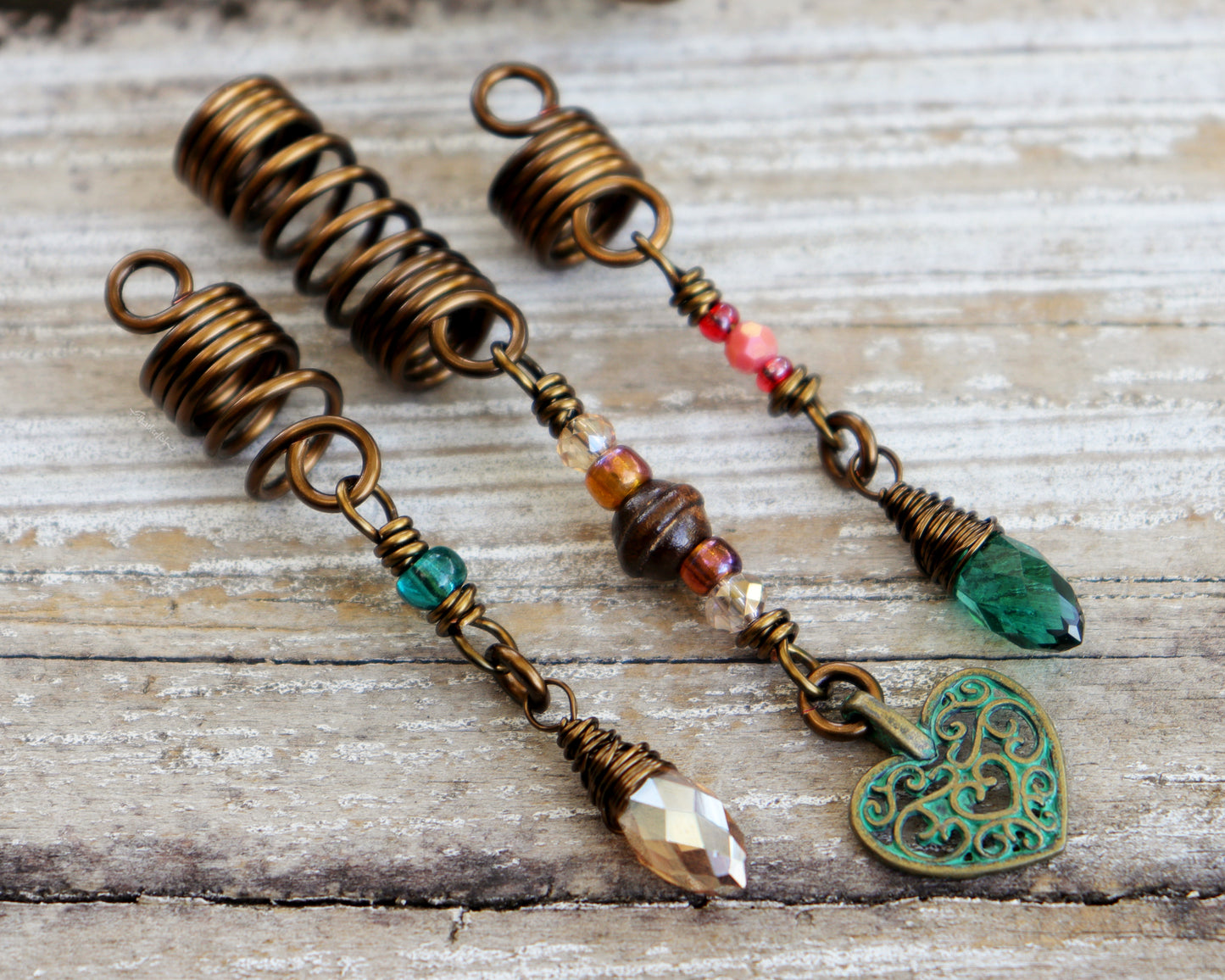 Set of 3 dreadlock beads on a wood background.