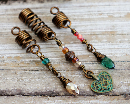 Set of 3 dreadlock beads on a wood background.