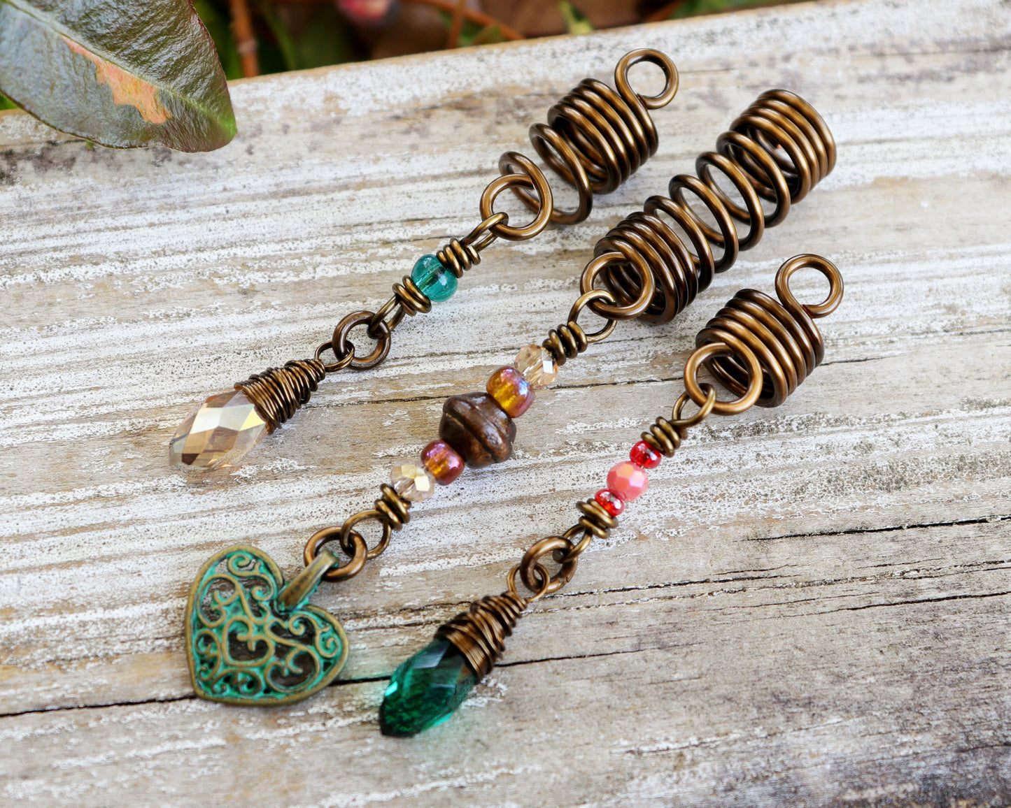 Set of 3 dreadlock beads on a wood background.